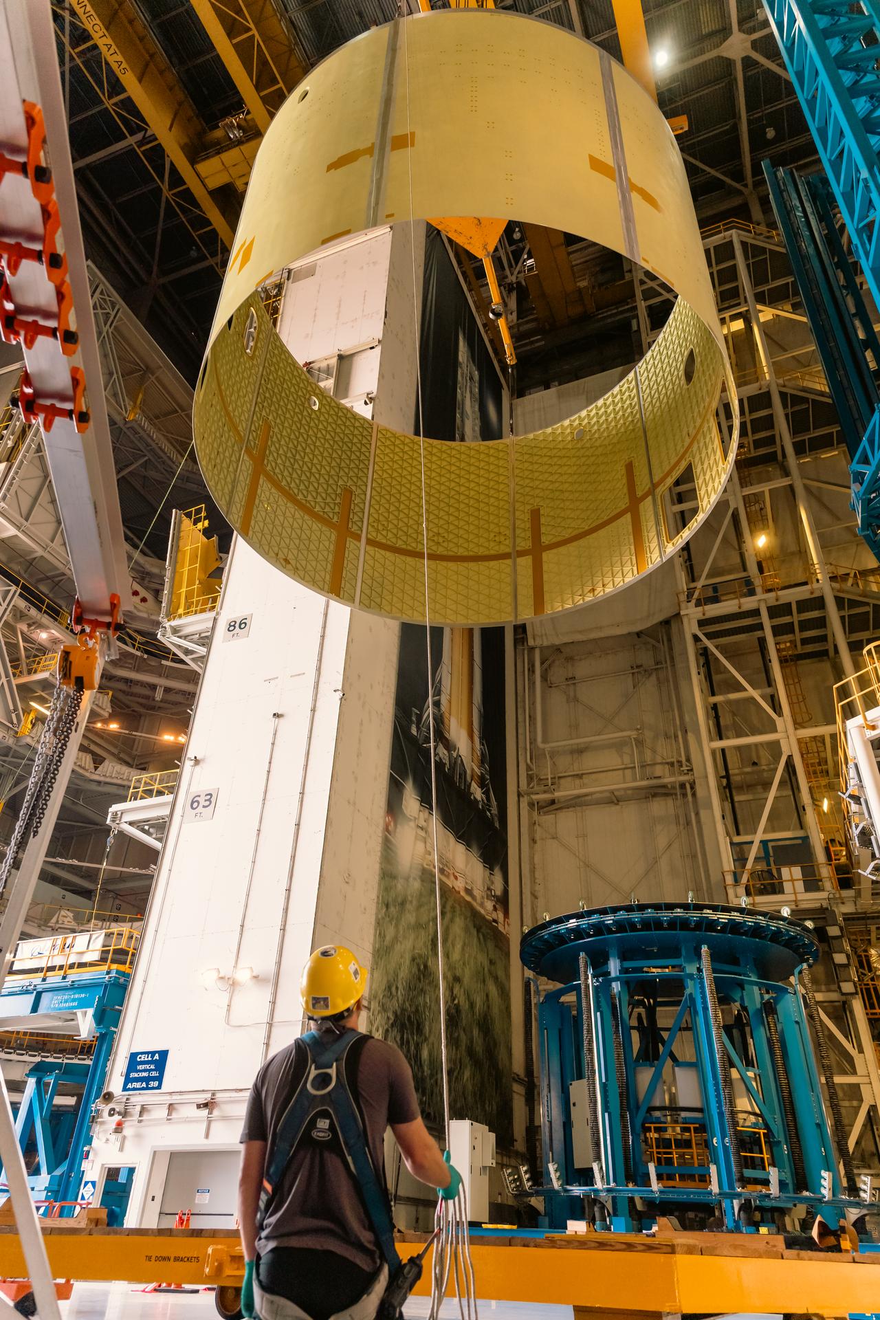 Teams at Michoud Assembly Facility in New Orleans load the engine section barrel into the vertical assembly center on Aug. 5, 2026. The engine section will be used on the SLS (Space Launch System) rocket’s core stage for the agency’s Artemis V mission. On the vertical assembly center tooling, teams will mate the flight hardware to a ring, which will serve as an attachment point for the liquid hydrogen tank later in the production process. The engine section is one of five major elements that make up the 212-foot-tall SLS rocket stage; and houses various avionic systems, the engine thrust structure, and four RS-25 engines. The core stage produces more than two million pounds of thrust to help launch NASA’s Orion spacecraft, astronauts, and supplies beyond Earth’s orbit and to the lunar surface for Artemis.
